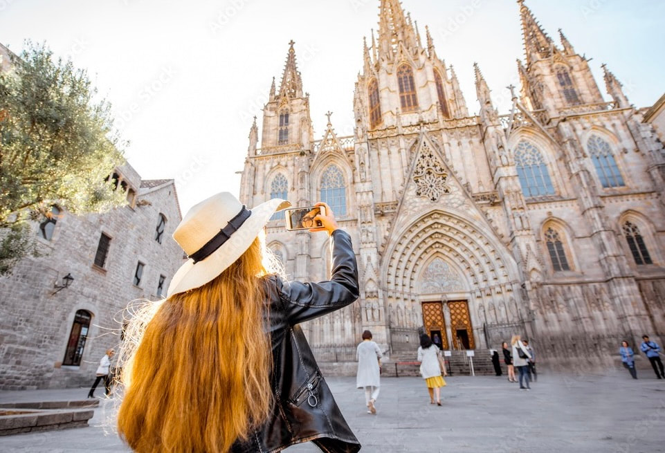 Woman taking a picture at a cathedral in Barcelona.